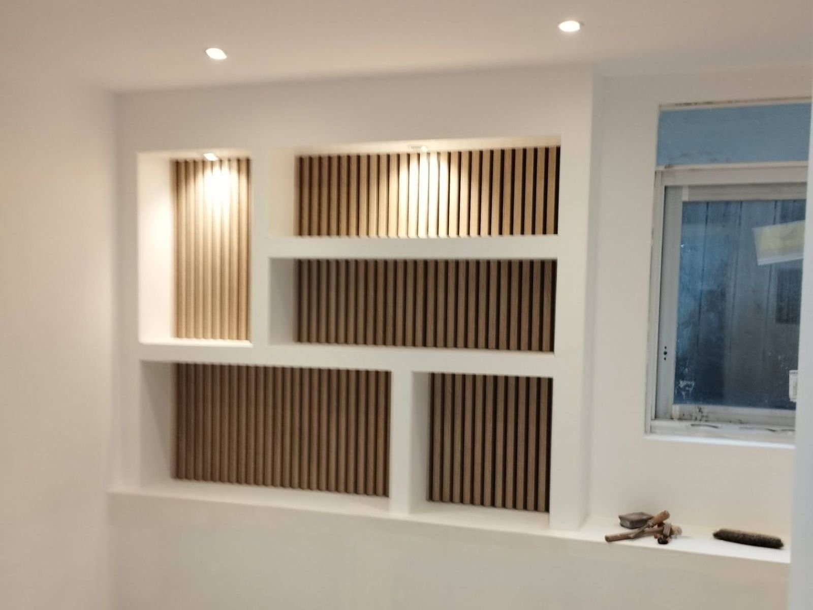 Aménagement d'un espace bien-être sur mesure avec claustras en bois et niches décoratives réalisé par LMA Savoir-Faire en Vendée.
