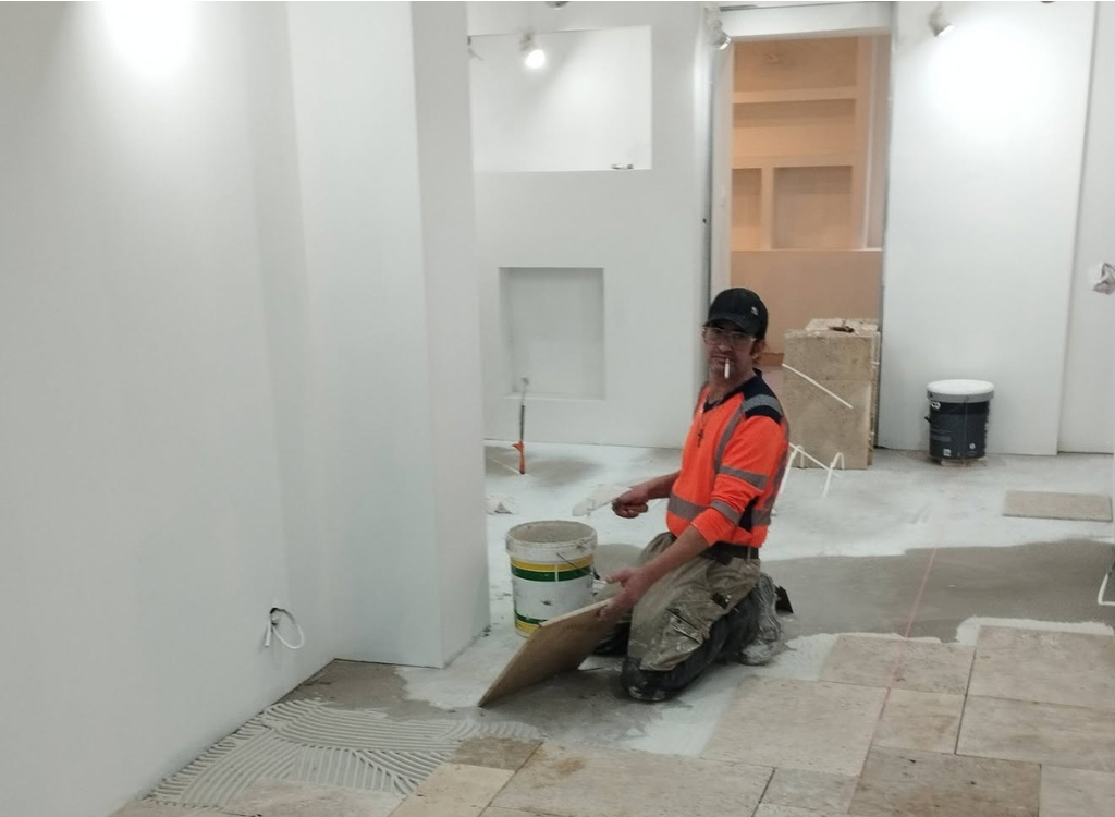 Pose du revêtement de sol lors de l'aménagement d'un espace bien-être par LMA Construction en Vendée.